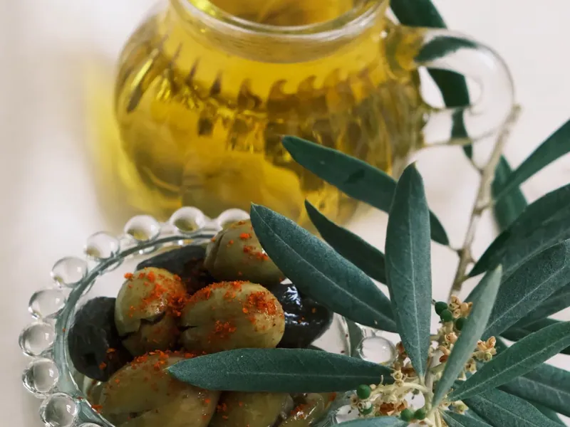 Petite carafe d'huile d'olive, olives et branche d'olivier